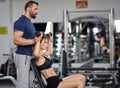 Personal trainer assisting young woman in the gym Royalty Free Stock Photo