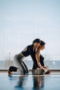 Personal trainer corrects his female pregnant client while doing yoga pose Royalty Free Stock Photo