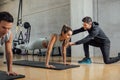 Personal trainer corrects woman& x27;s plank position at gym. Royalty Free Stock Photo