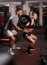 Personal trainer helping woman do squats Royalty Free Stock Photo