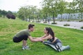 Personal trainer helping young woman doing splits and stretching exercises during fitness workout in a park Royalty Free Stock Photo