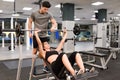 Personal trainer helping a young woman lift weights Royalty Free Stock Photo