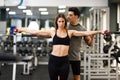 Personal trainer helping a young woman lift weights Royalty Free Stock Photo