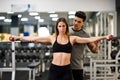 Personal trainer helping a young woman lift weights Royalty Free Stock Photo