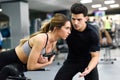 Personal trainer helping young woman lift weights Royalty Free Stock Photo