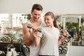 Personal trainer helping a young woman lift weights Royalty Free Stock Photo