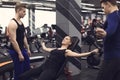 Personal trainer helping young woman to do exercises with dumbbells in gym Royalty Free Stock Photo