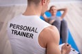 Personal Trainer Looking At Woman Doing Exercise
