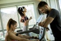 Personal trainer with young woman on cycling machine at the gym Royalty Free Stock Photo