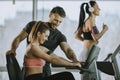 Personal trainer with young woman on cycling machine at the gym Royalty Free Stock Photo