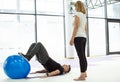 Personal trainer shows exercise with ball