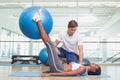 Personal trainer working with client holding exercise ball