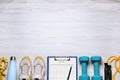 Personal training. Clipboard with workout plan, sneakers and sports equipment on white wooden table, flat lay. Space for text Royalty Free Stock Photo