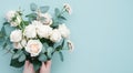 Elegant Handcrafted Floral Arrangement With Lush White Roses and Greenery on a Pastel Background