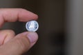 Persons hand holding out a dime coin or ten cents, the Currency of the Canada - on a brown background. Money exchange