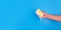 Persons hand holding yellow sponge for dish wash. Washcloth covered in soap. Domestic chores and supplies concept. Sensitive