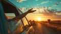 Persons hand outside of window feeing the warm rays of sunshine. Sea side road trip vacation