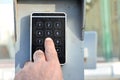 a persons hand pressing a password on a numerical keypad to lock or unlock an alarm system, opening garage gate for car entry,