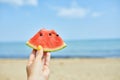 Hand Holding a Slice of Watermelon on a Sunny Beach Day Royalty Free Stock Photo