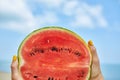 Hand Holding a Slice of Watermelon on a Sunny Beach Day Royalty Free Stock Photo