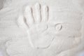 A persons handprint on the sand top view