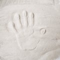 A persons handprint on the sand top view