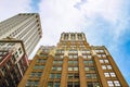 Perspective view of new and old office buildings looking up at them from ground level against cloudy blue sky - room for copy Royalty Free Stock Photo