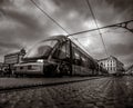 Perspective close-up of the Porto tram or metro train circulating on the tracks on the Dom Luis bridge at sunset, under a cloudy Royalty Free Stock Photo