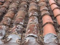 perspective close up of red old repaired terracotta roof tiles with damage and texture Royalty Free Stock Photo