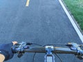 Perspective of a cyclist riding a bike on a road. Holding a handlebar while riding Royalty Free Stock Photo