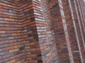 Perspective diagonal view on abstract brown red brick wall with columns with blured background. Architecture element brown brick w Royalty Free Stock Photo