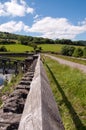 Perspective down the wooden railing in the British countryside.