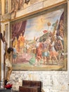 Perspective of interior decoration of catholic church showing a wooden crucifix in front of religious painting on a marble wall