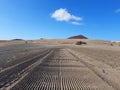 Perspective of sand rutted road in desert and volcanic landscape. Background of raked white sand. Clean beach sand texture with Royalty Free Stock Photo