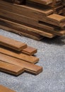 Group of hardwood floorboards with wooden planks stack on gravel stone floor in vertical frame