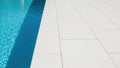 Large white tiles next to blue pool. Royalty Free Stock Photo