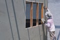 Asian builder worker plastering cement wall in construction site