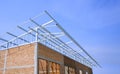 Brick wall and shed roof framing structure of row houses in under construction against blue sky Royalty Free Stock Photo