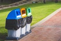 colorful garbage bins for separate waste sorting on stone tiles pavement in public park area Royalty Free Stock Photo