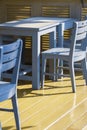 Dining table set on yellow wooden floor in terrace area of retro coffee shop in vertical frame Royalty Free Stock Photo