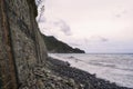 Perspective of a stone wall on a rocky beach, a windy day.