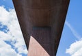 Perspective from under a huge, concrete bridge against summer sky Royalty Free Stock Photo