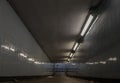 Perspective view of Ambient public underpass with white tiled walls and stripes of ceiling neon lights