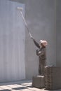 Asian builder worker painting white primer on concrete wall in house construction site