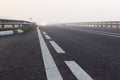 Perspective view of asphalt  road with a car headlights in a white fog in the morning Royalty Free Stock Photo