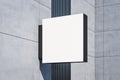 Perspective view on blank white illuminated square screen on modern building grey wall with place for your logo or company name. Royalty Free Stock Photo