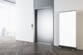Perspective view on blank white poster on wooden parquet floor in sunlit modern office hall with light wall, metallic elevator Royalty Free Stock Photo