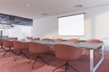 Perspective view on blank white projector screen with place for your logo or text on light wall in spacious conference room with Royalty Free Stock Photo