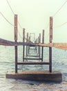 Perspective view of a broken rusty iron jetty running into to sea on a sunlit misty morning