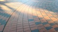 perspective view of brown brick paving walking way with sun light on evening time background. Royalty Free Stock Photo